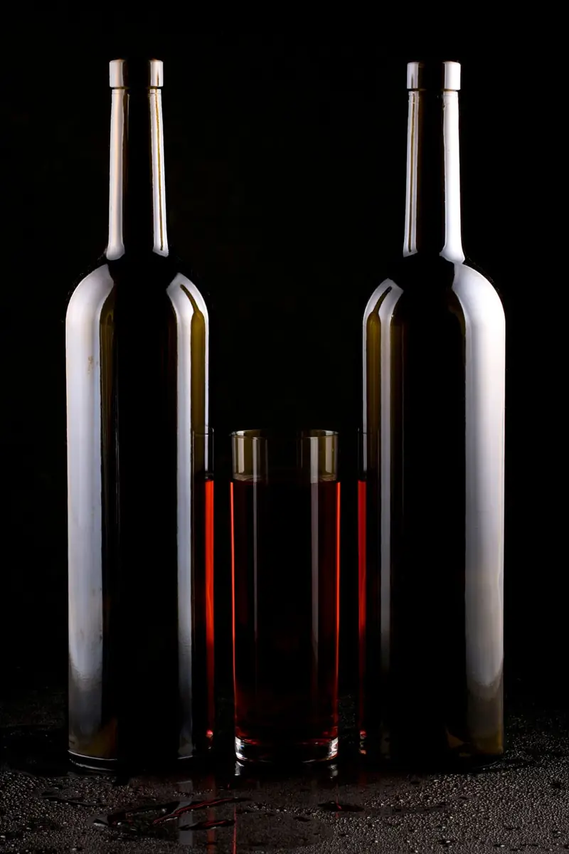Tres botellas sobre fondo oscuro