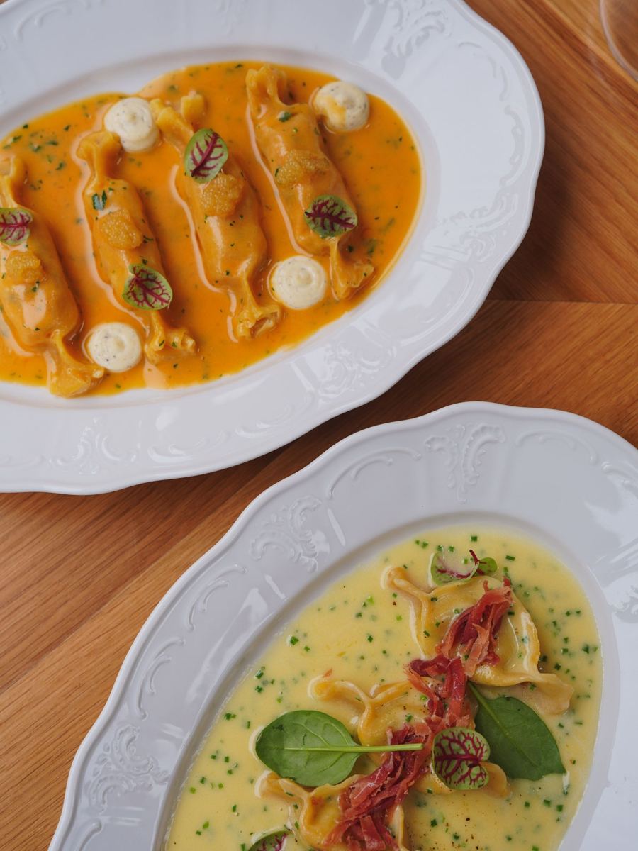Tortelli en crema de azafrán, vistos desde arriba en platos blancos